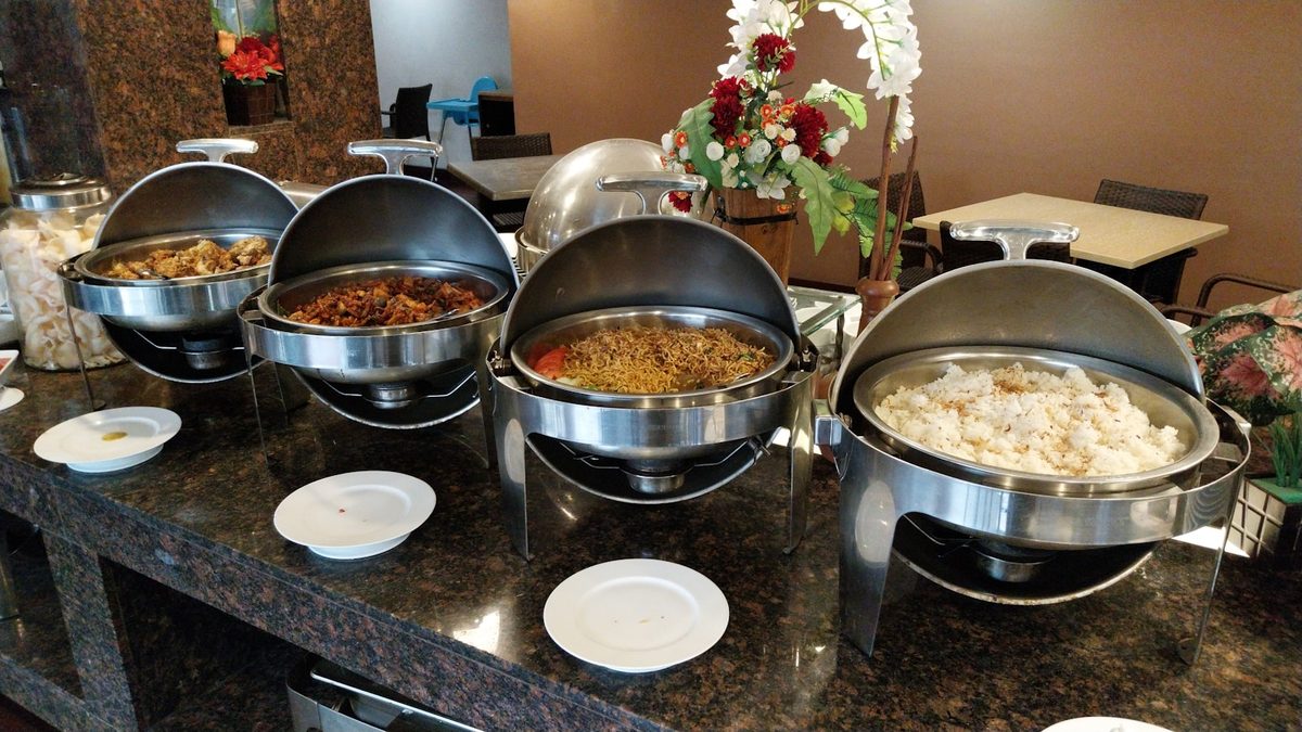 Buffet counter filled with hot dishes, salads and desserts