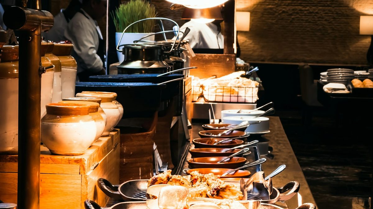 A long buffet counter lined with hot dishes, salads and desserts at a restaurant