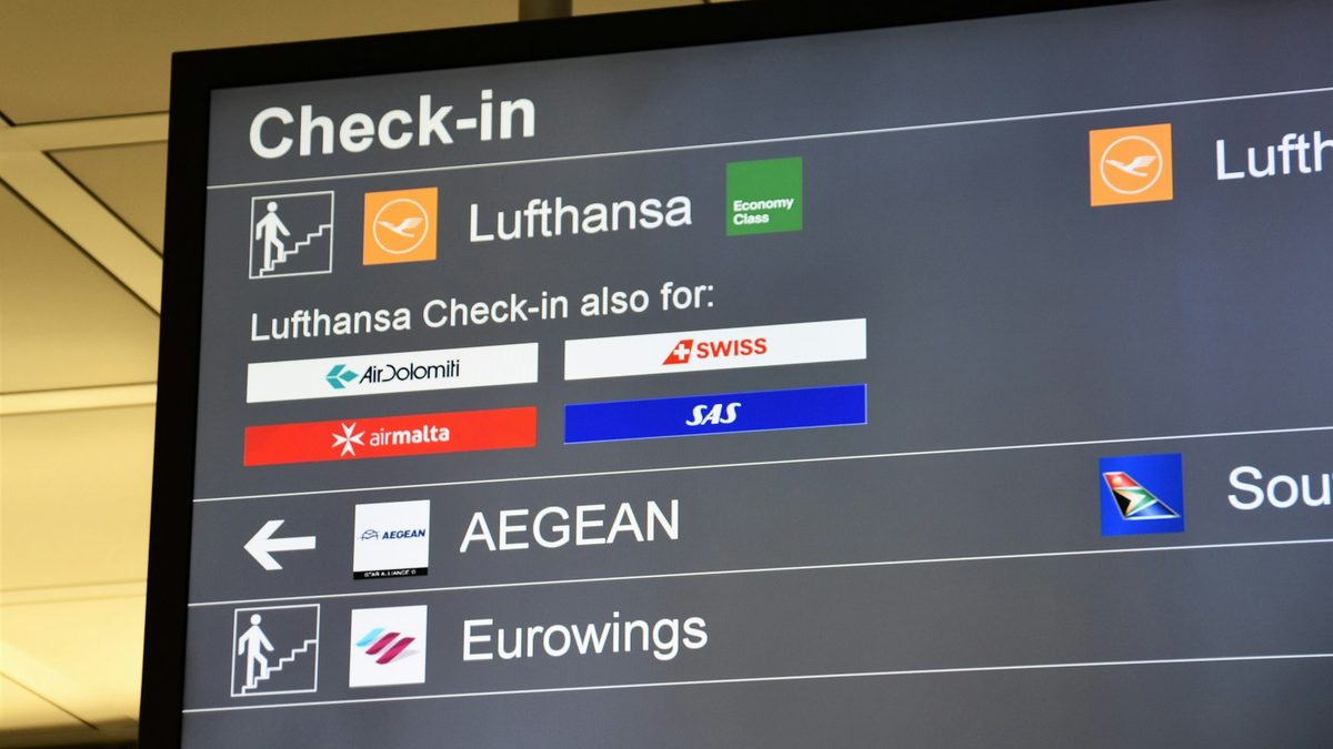 Airport information screen listing airline check-in desks and departure areas