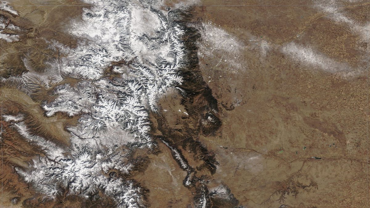 Satellite view of Colorado with the Rocky Mountains covered in snow and the eastern plains bare brown