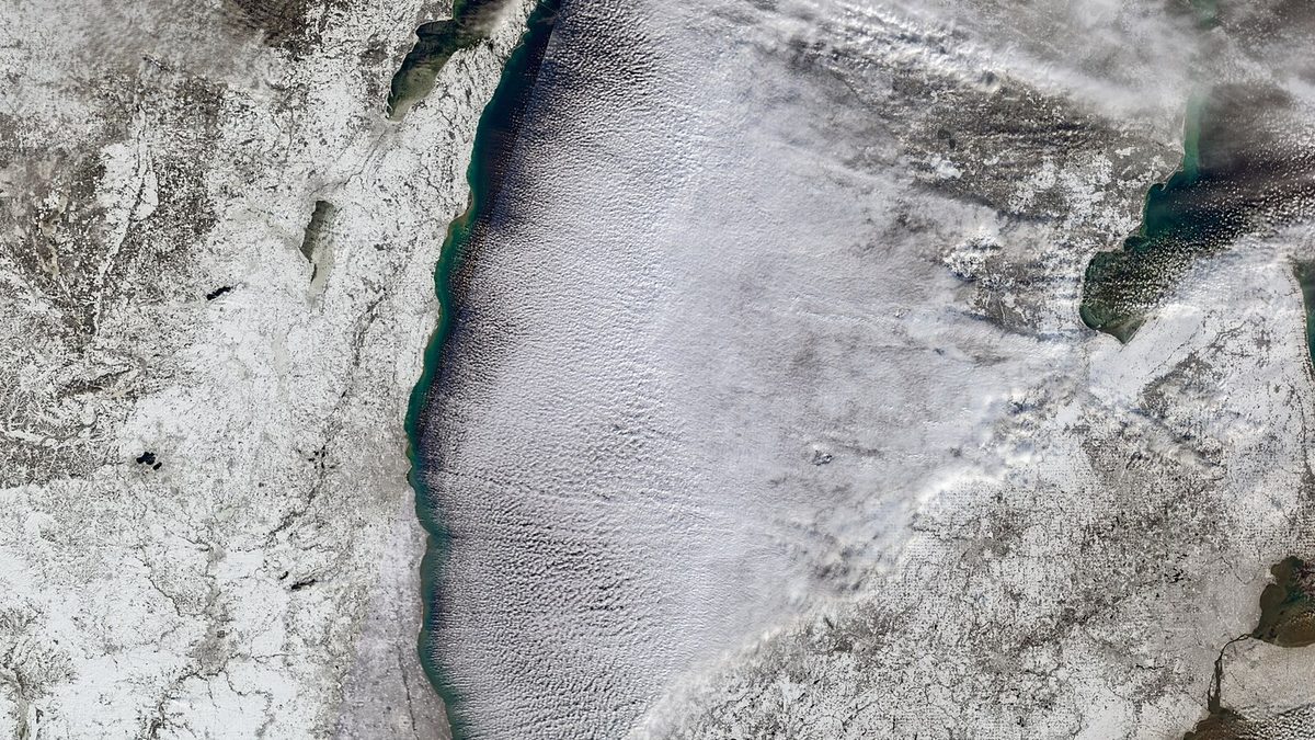 Satellite view of parallel lake effect cloud bands streaming east across Lake Michigan onto a snow-covered western Michigan
